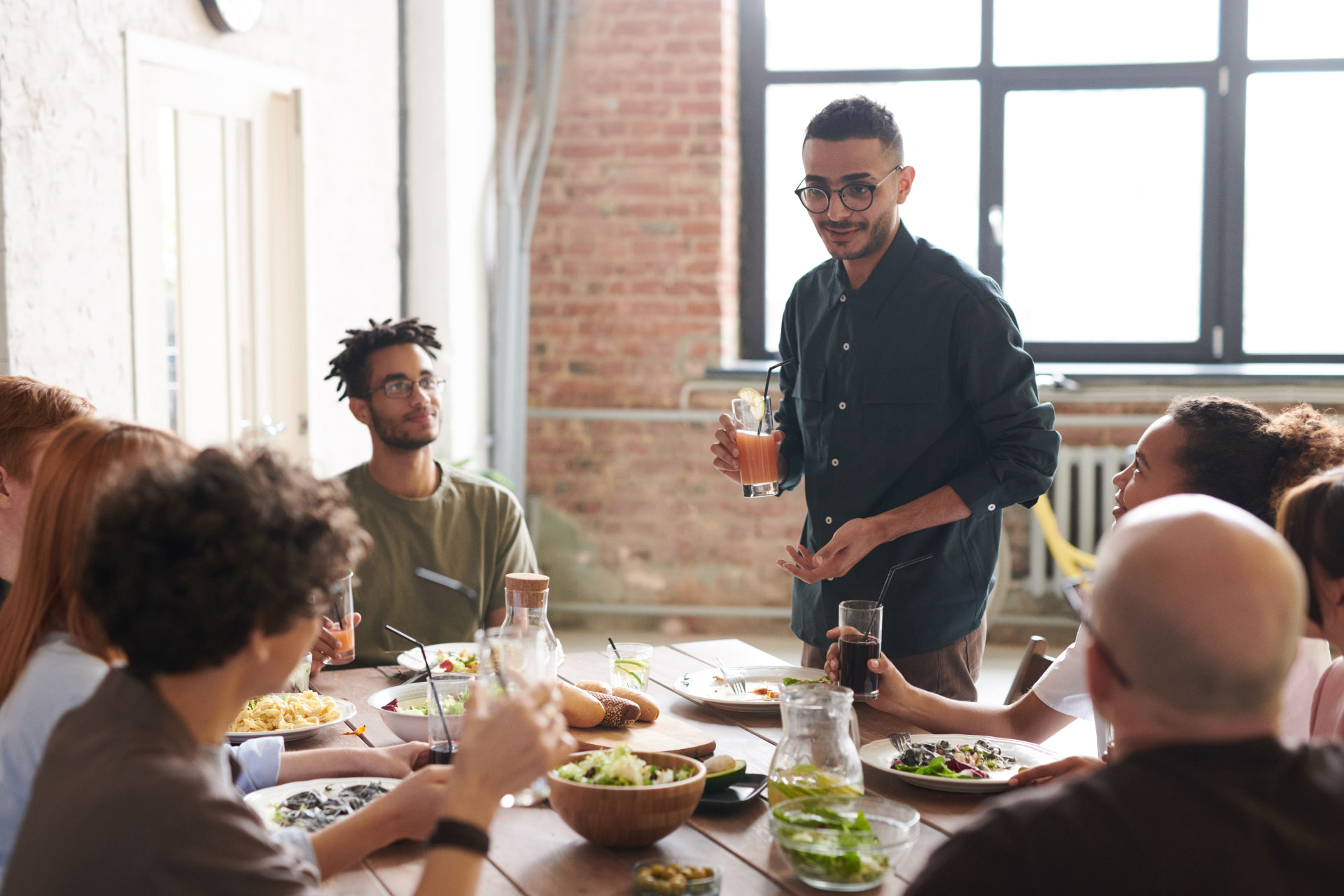 Groupe d'amis levant leurs verres autour d'une table lors d'une fête privée